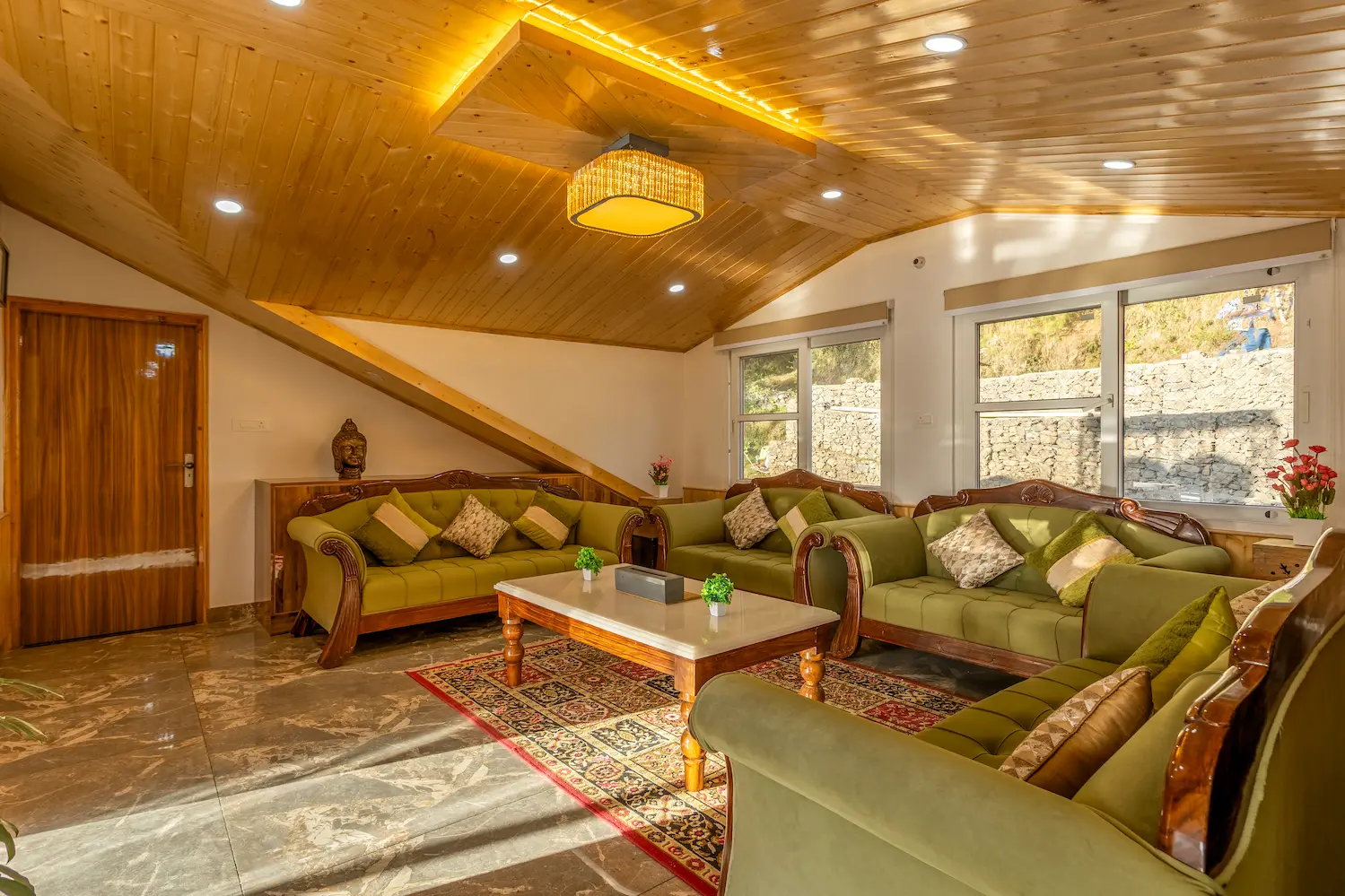 Daylit living room with windows opening onto the hillside behind the villa