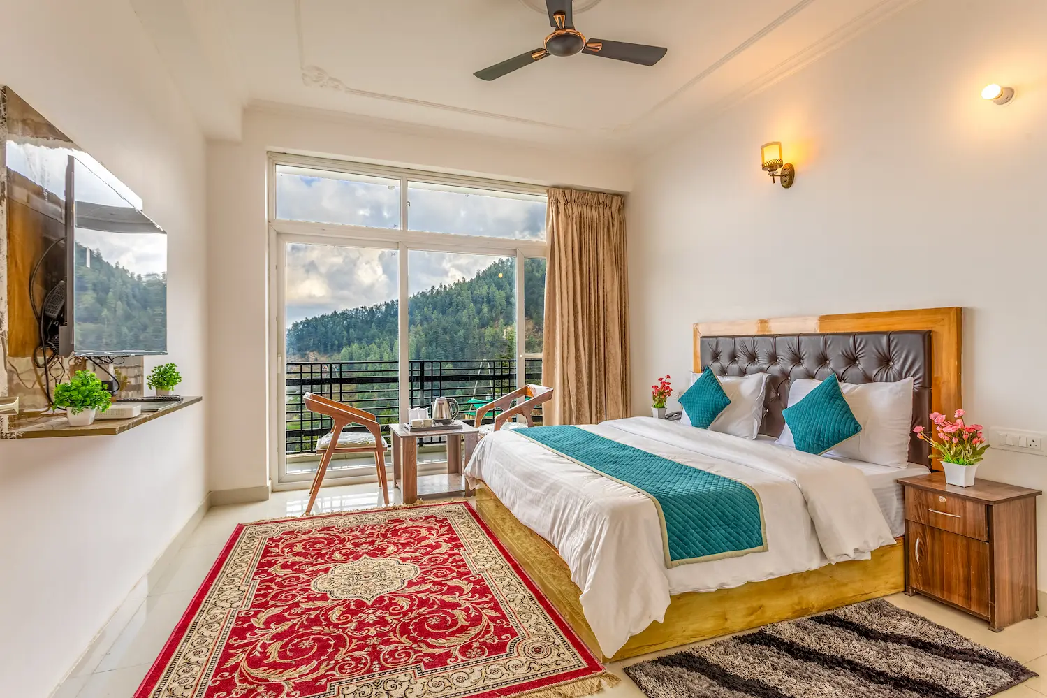 Bedroom in teal and white with a private balcony over the forested slope