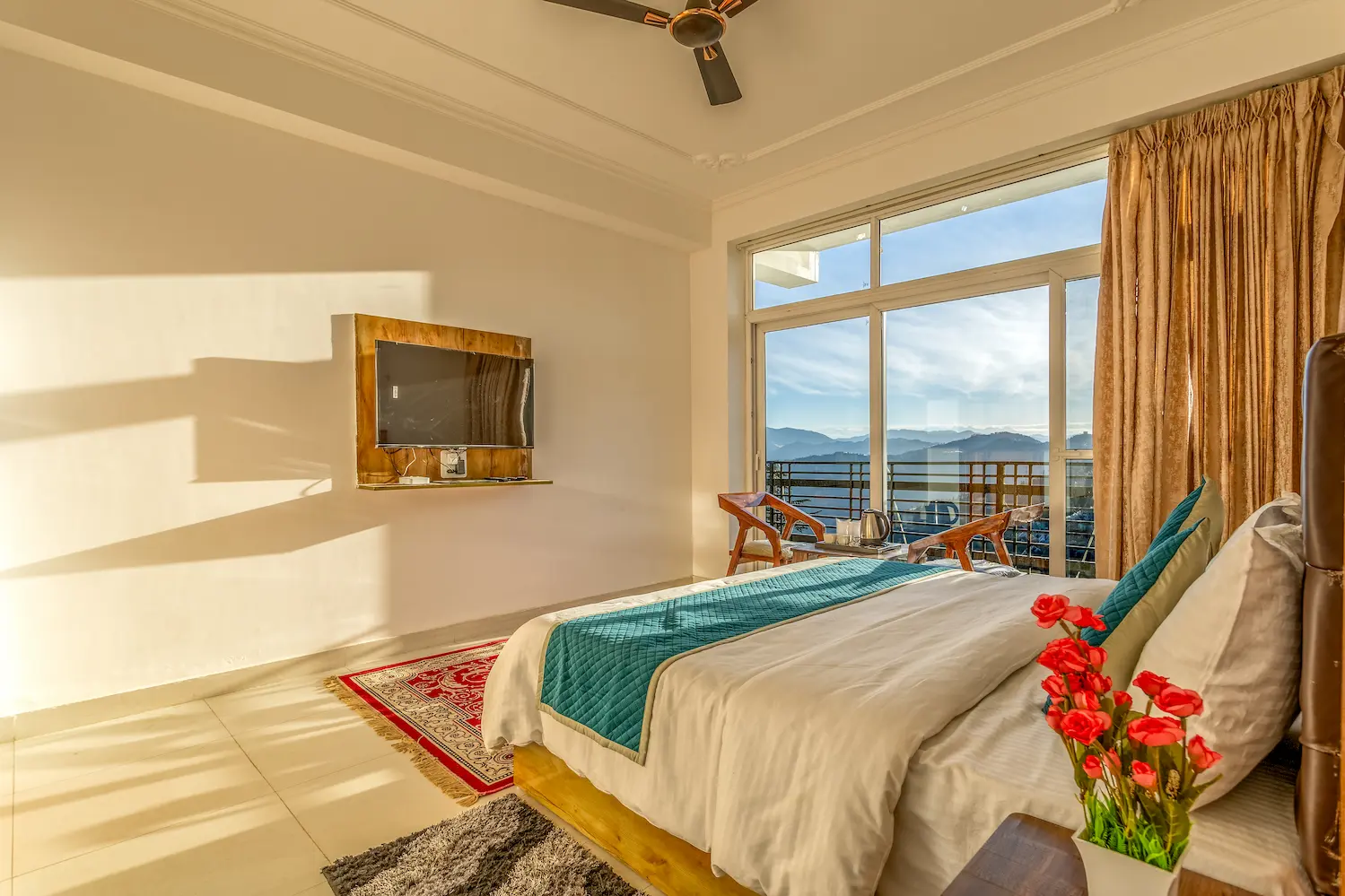 Late afternoon light across a bedroom floor, with the valley framed by the balcony doors