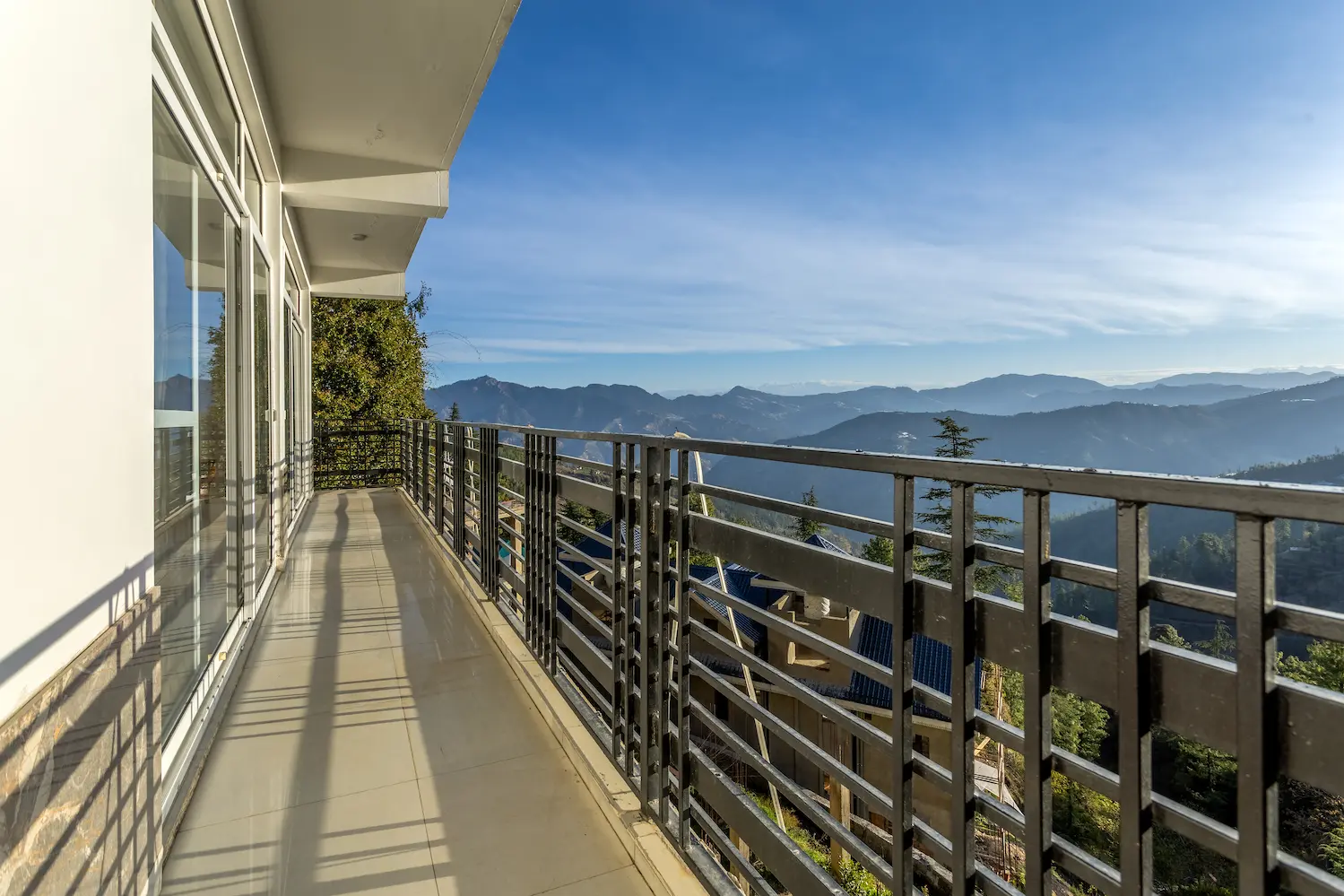 Balcony walkway running past the bedroom doors, open to the ridgelines below