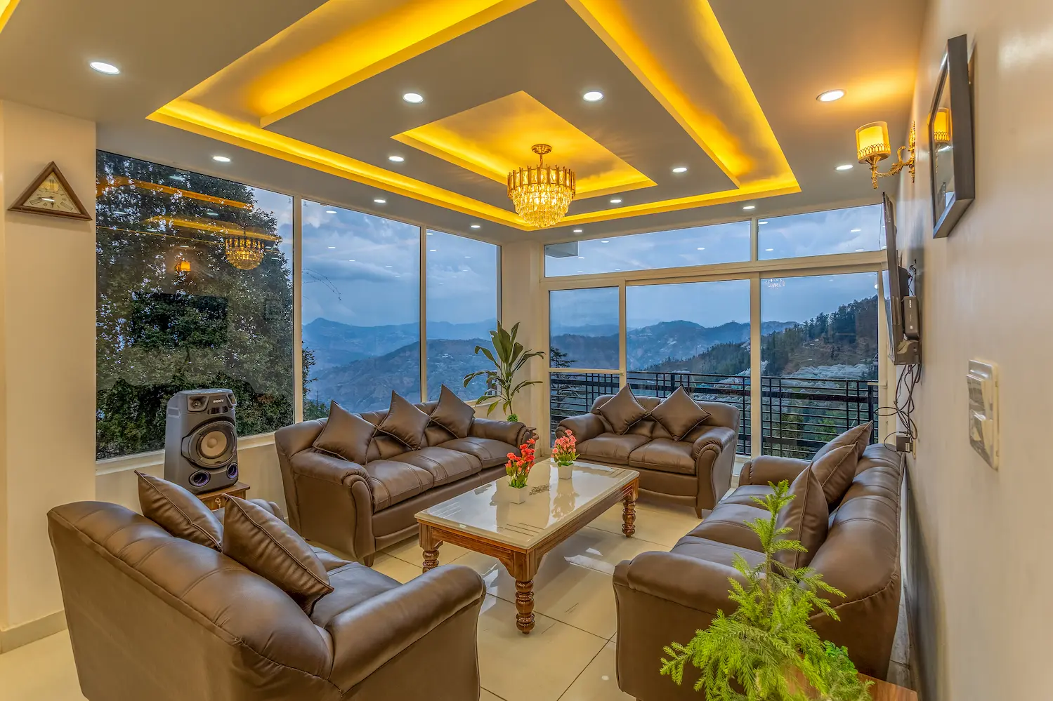 Main living room at dusk, its glass walls looking out over the darkening ridgelines