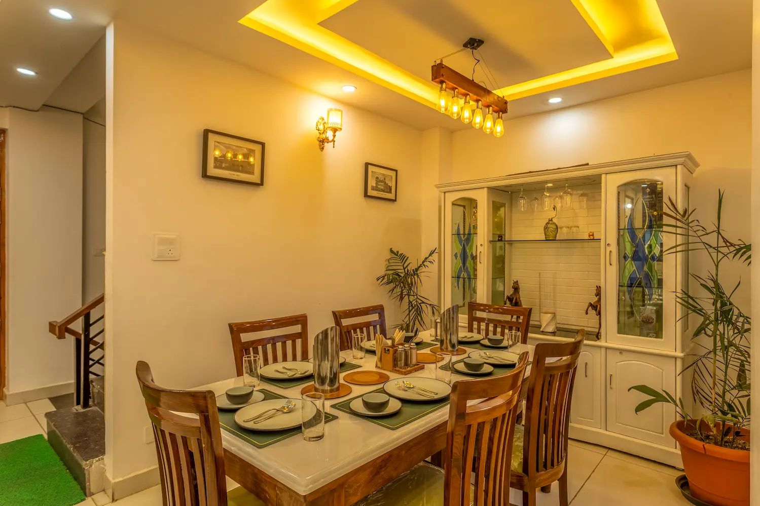 Dining area laid for a full table, with the crockery cabinet and stairs to the upper floors