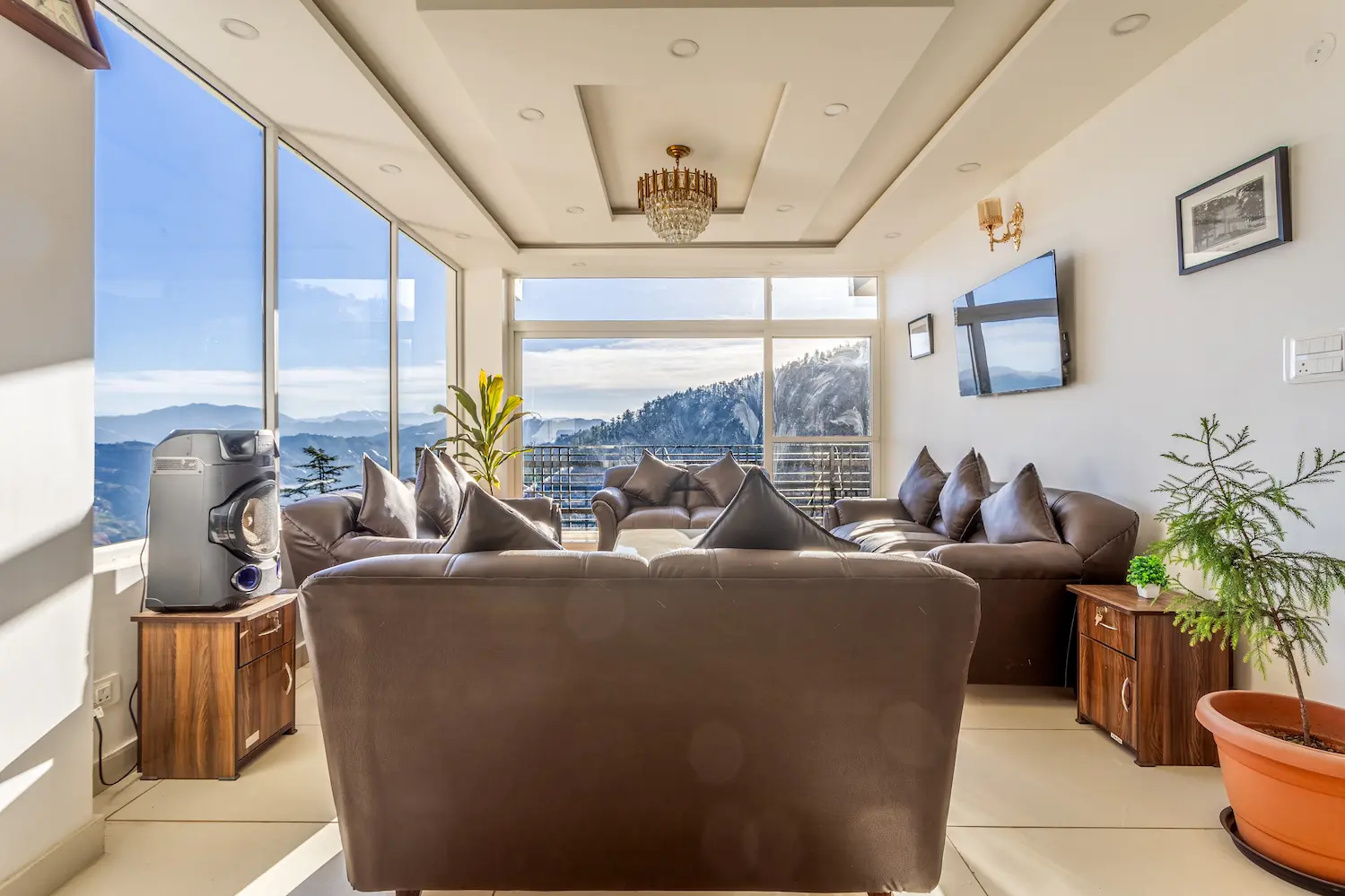 The same living room by day, sofas drawn around the windows with mountains on three sides
